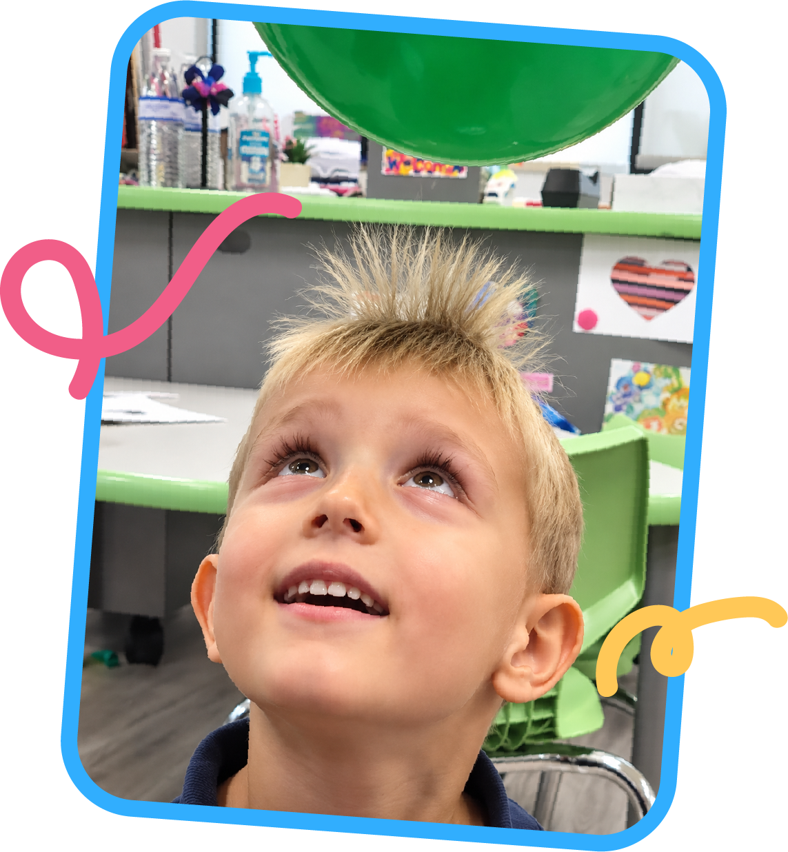 Young boy smiling with hair standing up from a static electricity balloon experiment at STEM Bright Beginnings childcare and daycare in Leander, TX