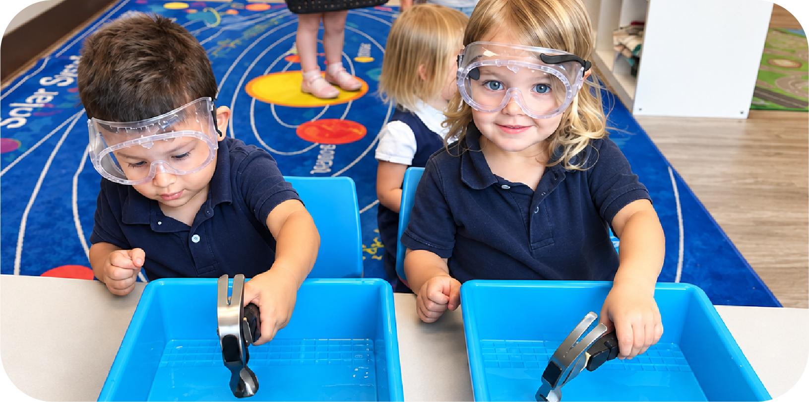 Toddlers wearing safety goggles doing a STEM water experiment at STEM Bright Beginnings daycare in Leander, TX