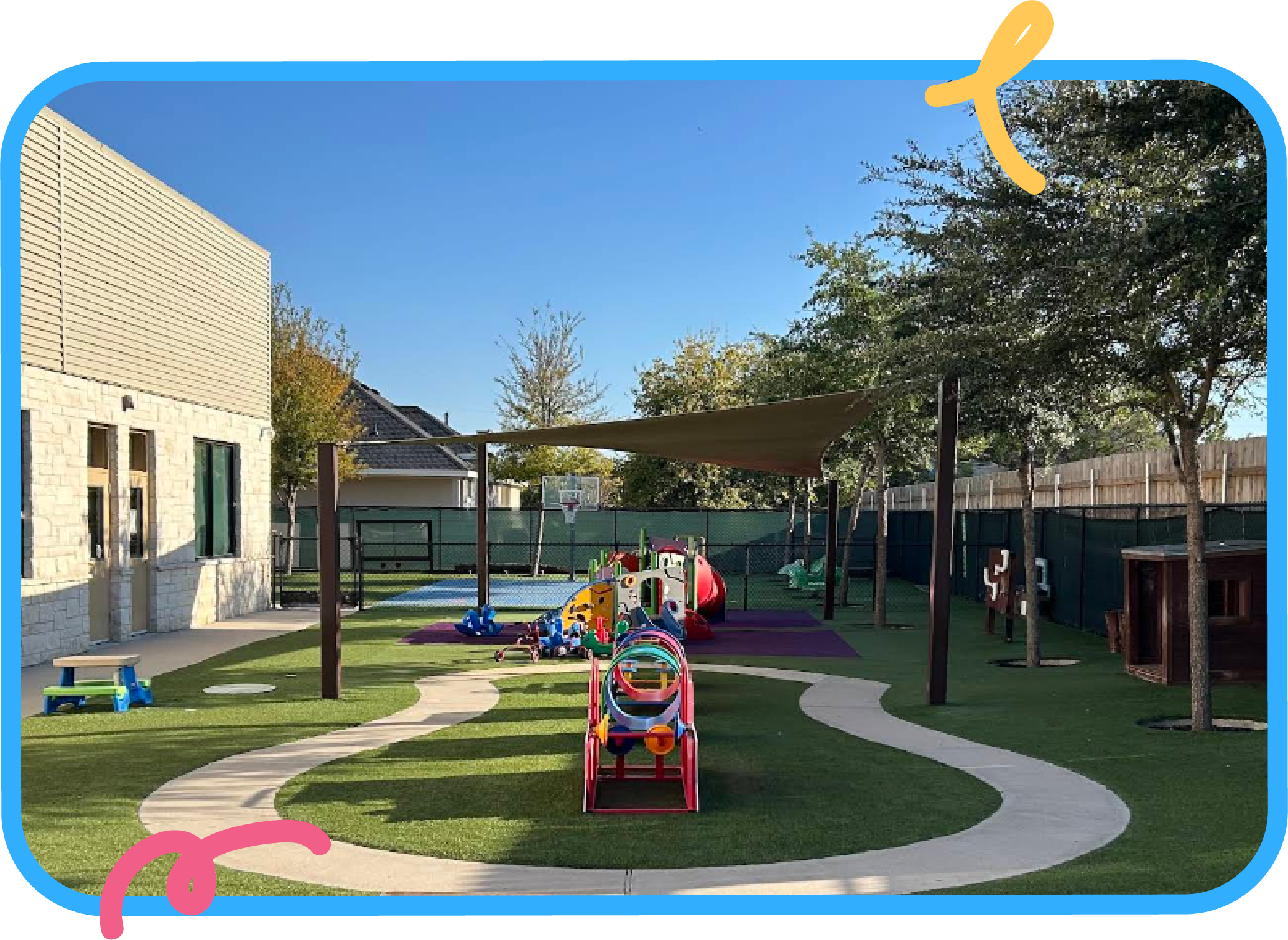 Shaded outdoor playground with play structures, turf, and walking paths at STEM Bright Beginnings childcare and daycare in Leander, TX